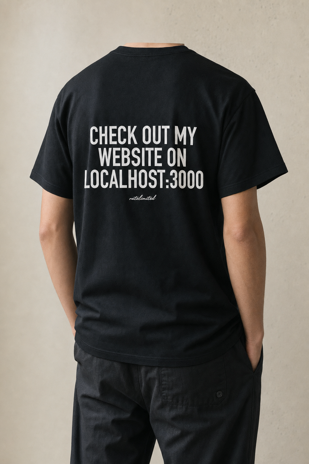 Model seen from behind wearing the black localhost:3000 tee, back print reading "Check out my website on localhost:3000"