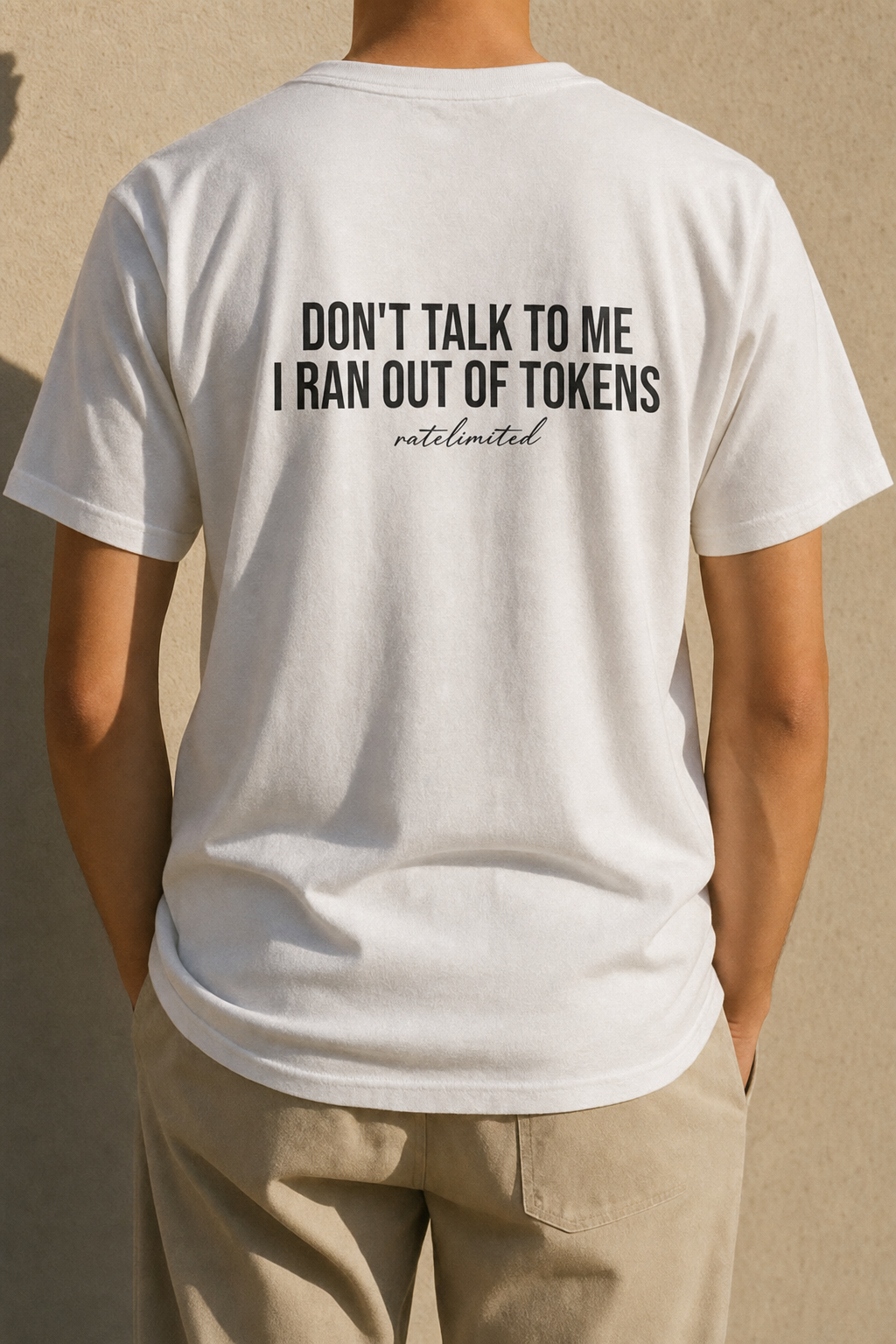 Model seen from behind wearing the white Out Of Tokens tee, back print reading "Don't talk to me, I ran out of tokens"